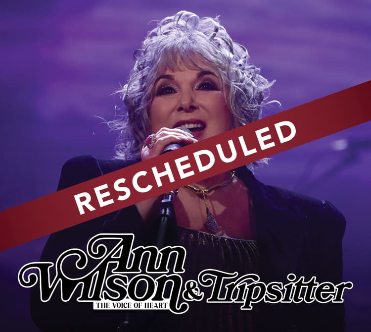 Female singer on stage, "Rescheduled" banner